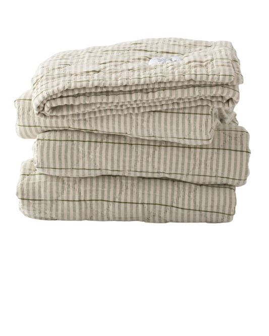 Heirloom‑inspired quilt folded featuring muted beige and olive green vertical stripes with soft textured stitching.