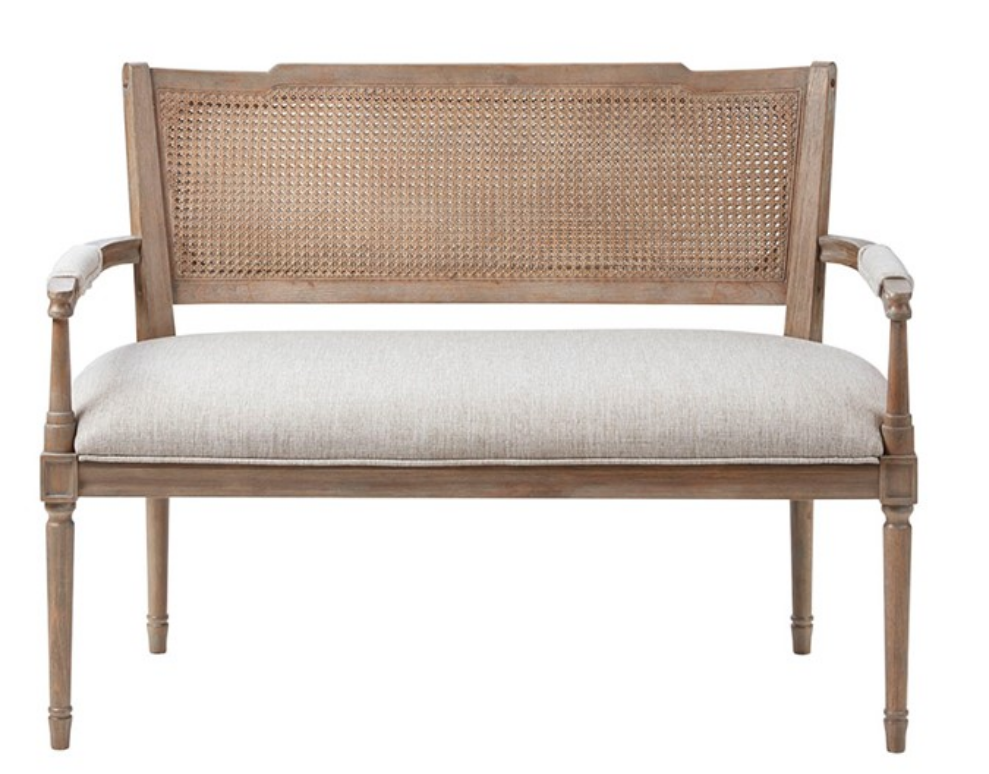 French cane settee with a woven shield back, light wood frame, and upholstered seat in a farmhouse‑inspired style.